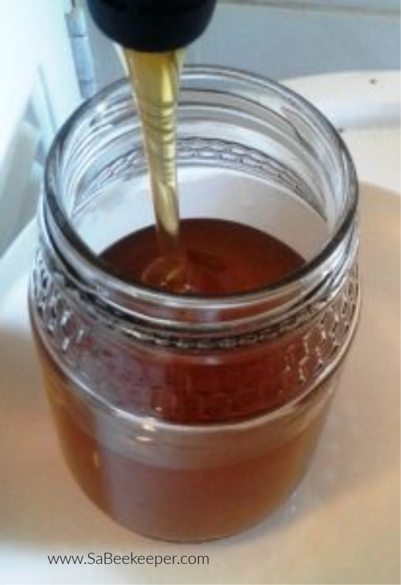 view the delicious dark organic honey being bottles into jars