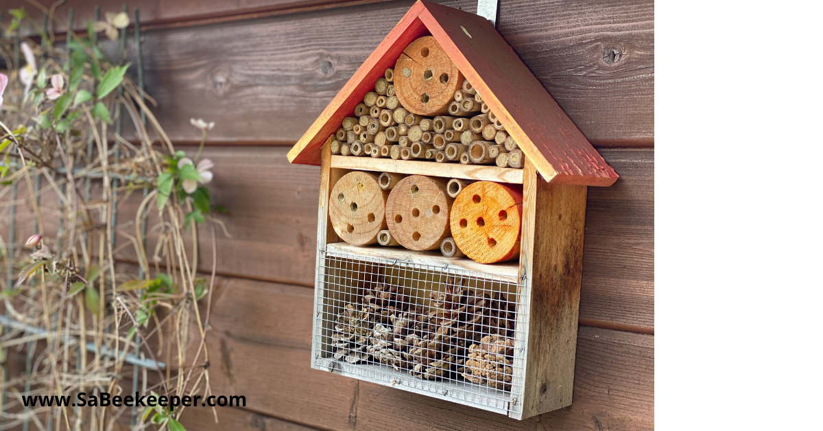 A homemade bee hotel hanging on a wall, a good size