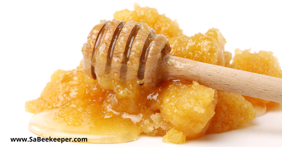 crystallized honey scooped out and a honey dripper in photo