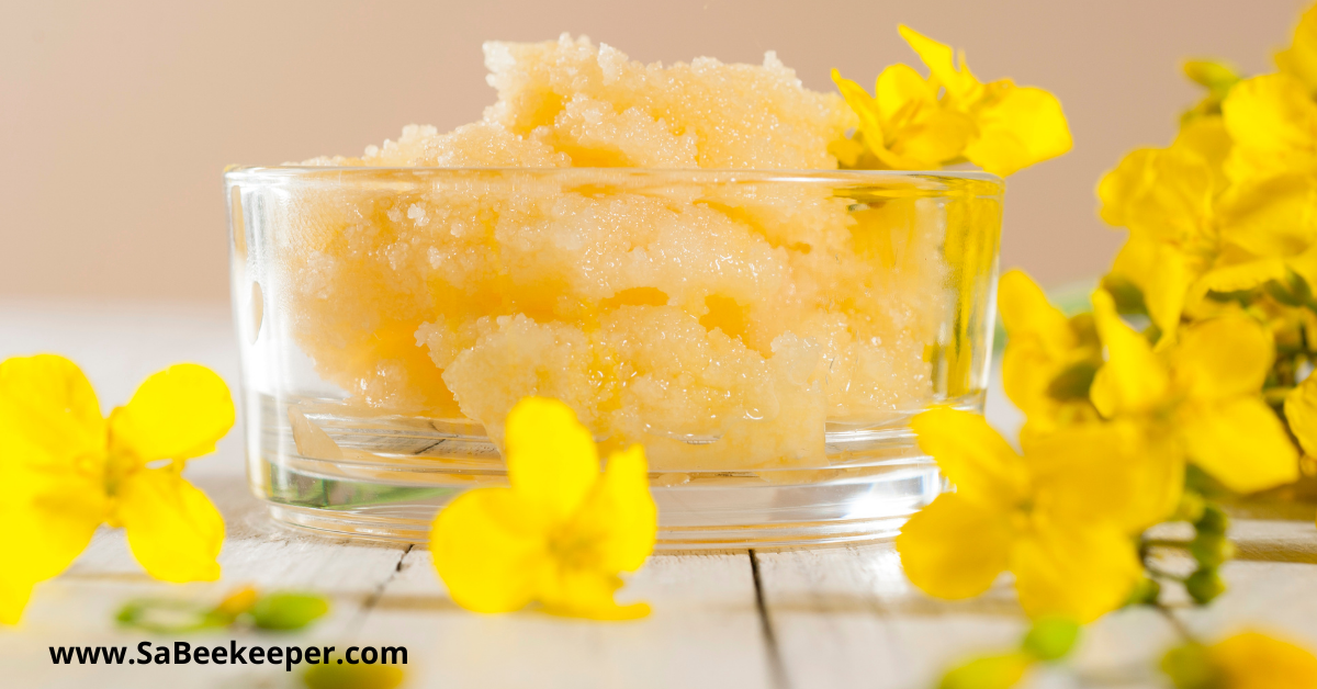 a bowl of crystalized honey. Canola honey and flowers on the table